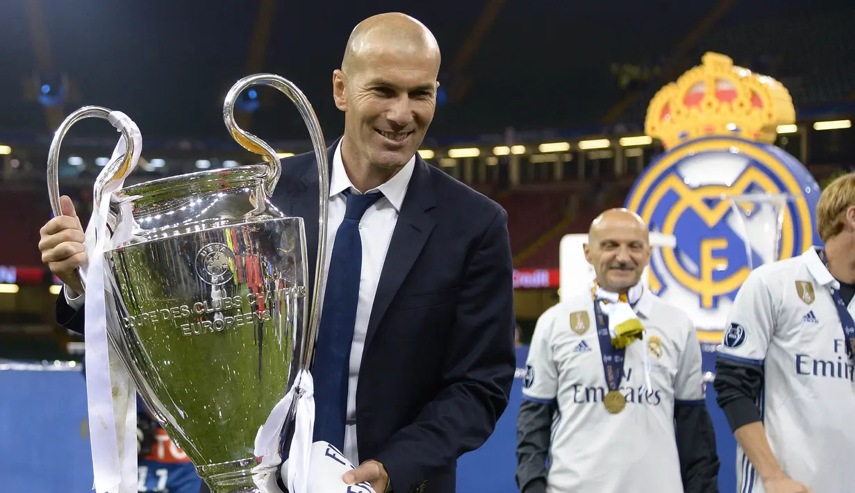 Pelatih Real Madrid, Zinedine Zidane, mengangkat trofi  usai memastikan diri sebagai juara Liga Champion dengan mengalahkan Juventus di Stadion Millennium, Cardiff, Sabtu (3/06/2017). Real Madrid menang 4-1. (AFP/ Filippo Monteforte)