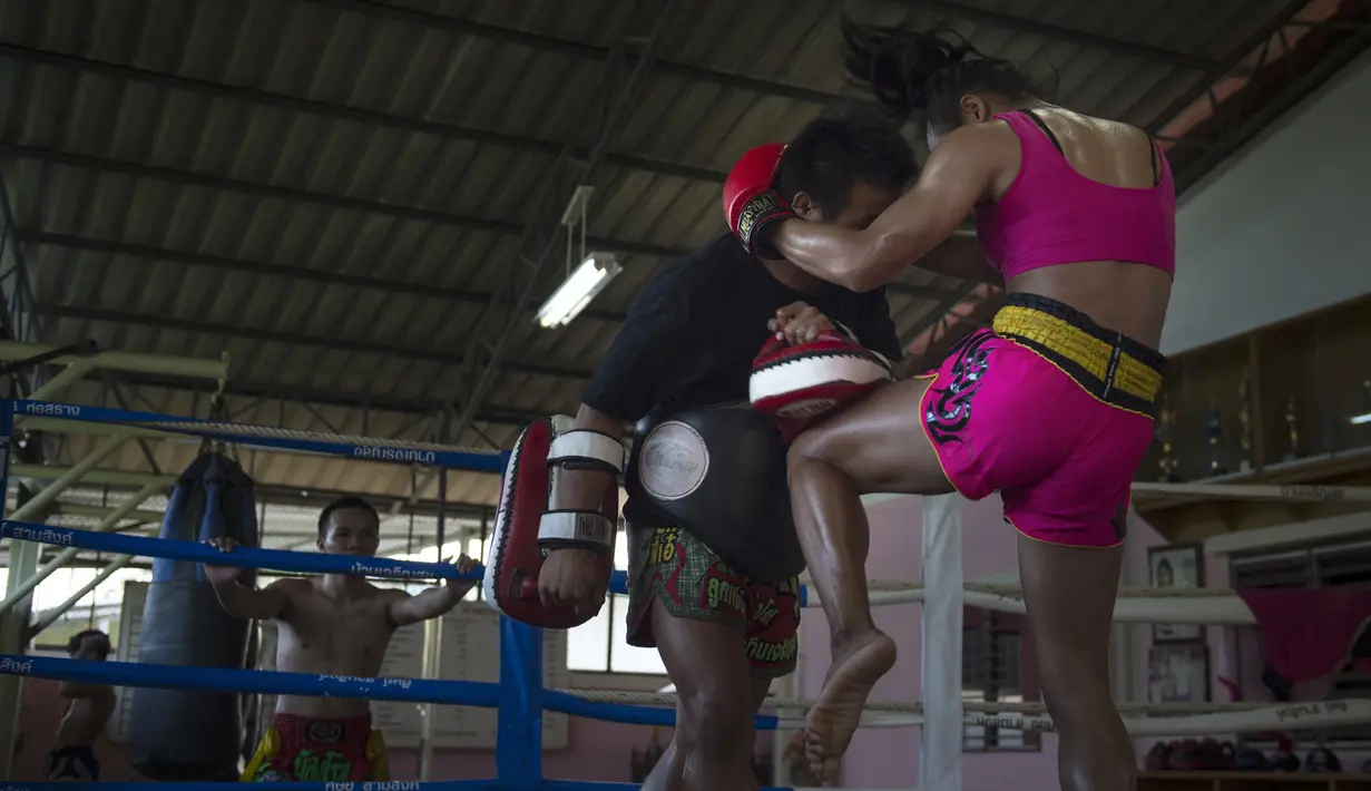 Petinju Muay Thai Nong Rose melakukan serangan dengan lututnya saat berlatih di provinsi Chachoengsao, Thailand (15/12). Bersama saudara laki-lakinya, petinju Muay Thai transgender ini melakukan sesi latihan. (AFP Photo)