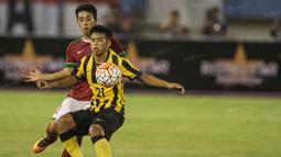 Bek saya Indonesia, Beny Wahyudi, berusaha menahan laju gelandang Malaysia, Muhammad Safawi. Sebelum laga ini timnas Merah Putih terakhir bertanding pada Maret 2015, kala itu menghadapi Myanmar. (Bola.com/Vitalis Yogi Trisna)