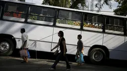 Warga berjalan melintas di depan pasar bus 'Sacolao' di Santa Teresa di Rio de Janeiro, Brasil, Selasa (7/7/2015). Pasar bus ini menjual sayur dan buah-buahan dengan harga yang terjangkau. (REUTERS/Pilar Olivares)