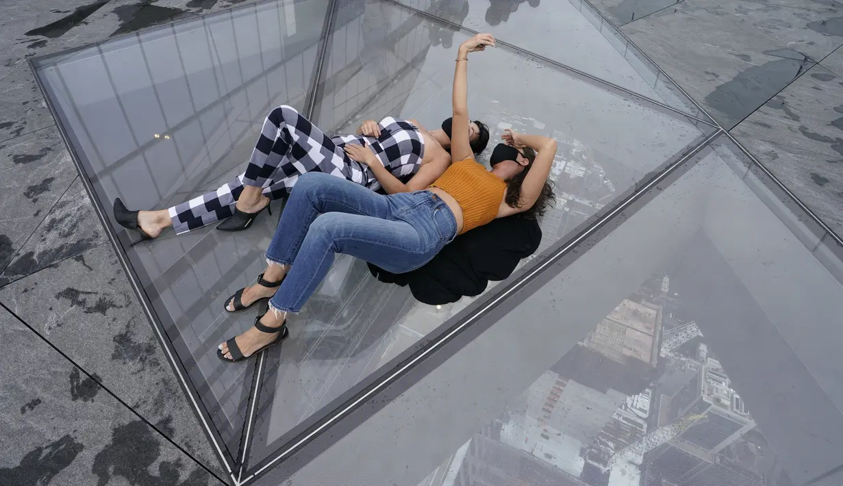 Pengunjung berswafoto dari Edge, dek langit tertinggi di luar ruangan di Western Hemisphere saat dibuka kembali untuk umum di New York, Rabu (2/9/2020). Dek yang berada di lantai 100 menara utama Hudson Yards itu memiliki tinggi 1.100 kaki atau setara 335 meter (TIMOTHY A. CLARY/AFP)