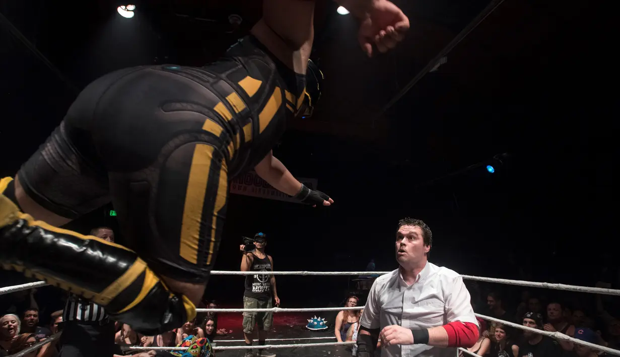 Pegulat Bat Manuel melompat bersiap menyerang lawannya saat pertandingan gulat Hoodslam di Oakland, California (7/7). Hoodslam adalah pertandingan gulat profesional bawah tanah (underground) yang berlangsung di Oakland. (AFP Photo/Josh Edelson)