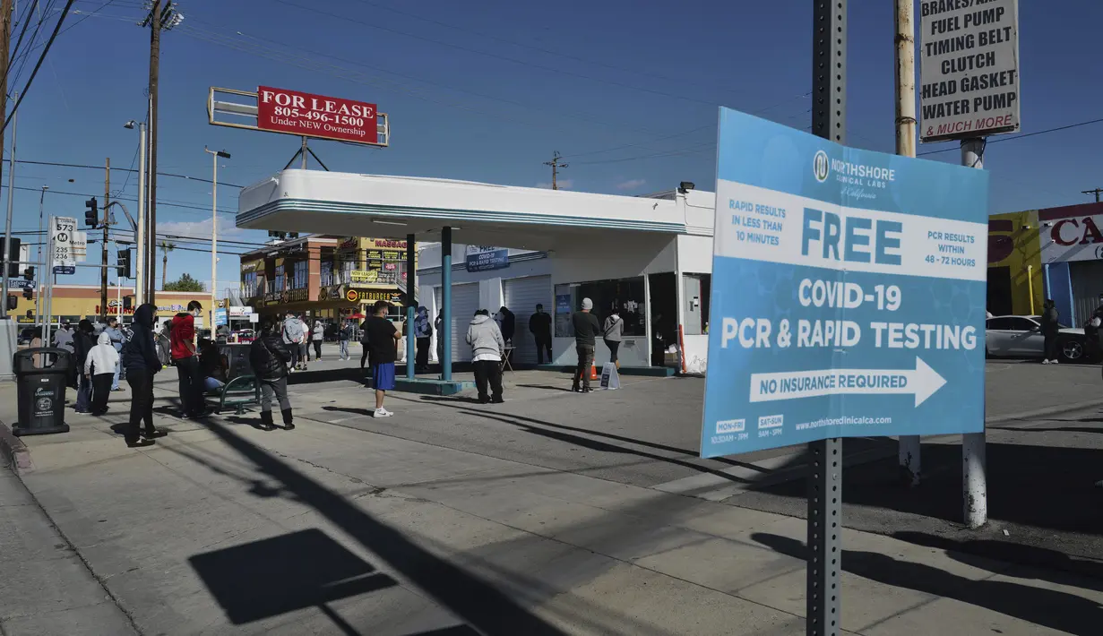Antrean orang-orang untuk tes diagnostik cepat (rapid test) COVID-19 gratis di sebuah pompa bensin, di bagian Reseda, Los Angeles, Minggu (26/12/2021). Tes gratis ini digelar saat California bersiap menghadapi lonjakan kasus setelah liburan. (AP Photo/Richard Vogel)