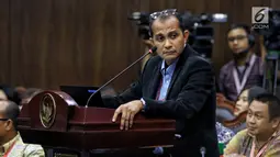 Ahli dari TKN Prof Edward Omar Syarief Hiariej saat memberi keterangan selama sidang lanjutan sengketa Pilpres 2019 di Gedung MK, Jakarta, Jumat (21/6/2019). Pokok keterangan yang disampaikan Edward terkait TSM dalam konteks UU Pemilu sebagaimana UU Nomor 7 Tahun 2017. (Liputan6.com/Johan Tallo)