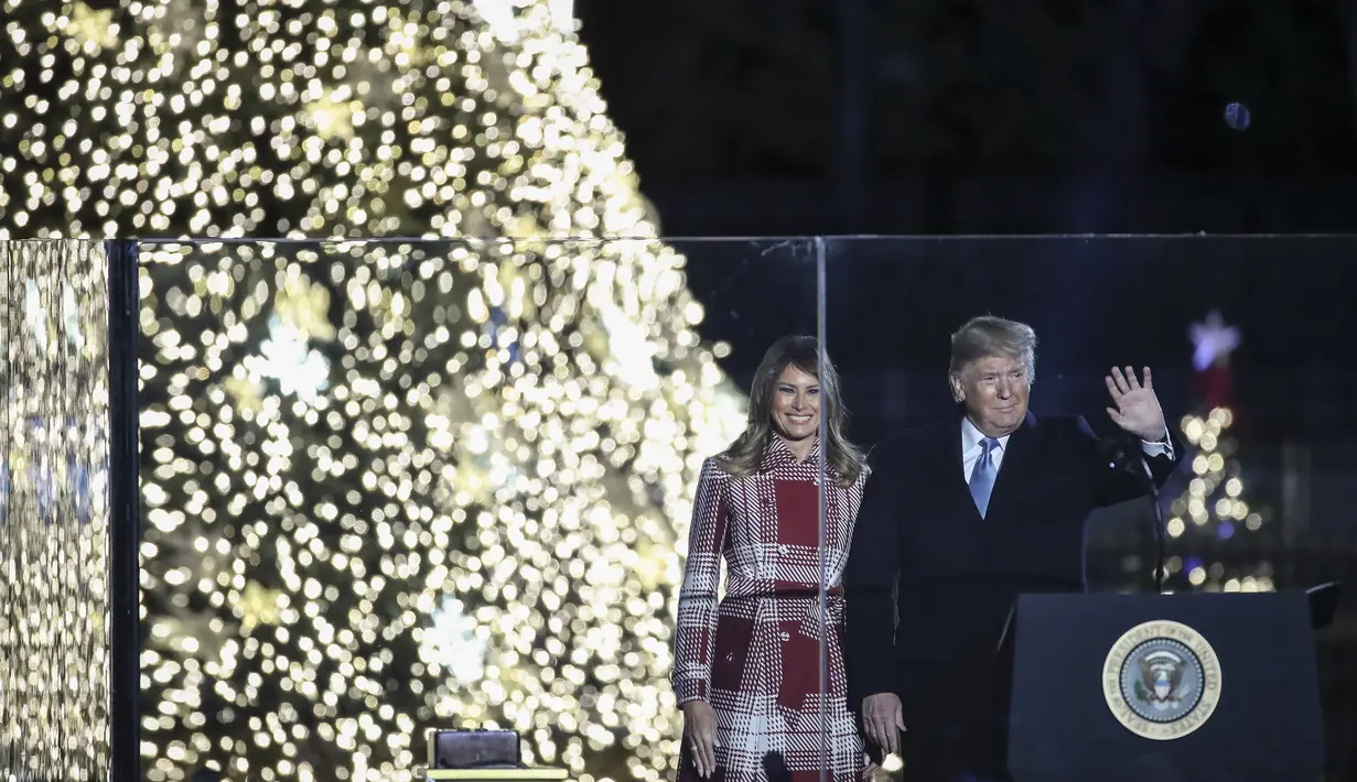 Presiden AS, Donald Trump dan ibu negara Melania Trump menghadiri upacara penerangan pohon cemara, yang menjadi Pohon Natal Nasional di taman sebelah selatan Gedung Putih, Kamis (5/12/2019). Pohon Natal Nasional tahun ini adalah cemara biru segar dari Colorado. (Drew Angerer/Getty Images/AFP)