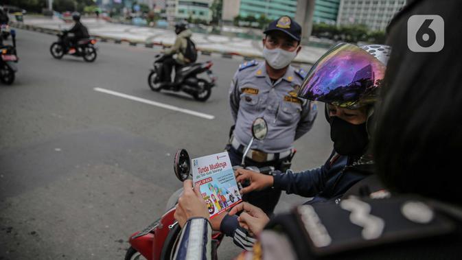 Pengendara memperhatikan saat polisi melakukan sosialisasi larangan mudik kepada pengguna jalan di kawasan Bundaran HI, Jakarta, Rabu (6/5/2020). Sosialisasi tersebut dilakukan demi memutus mata rantai penyebaran virus corona COVID-19 dari satu wilayah ke wilayah lain. (Liputan6.com/Faizal Fanani)