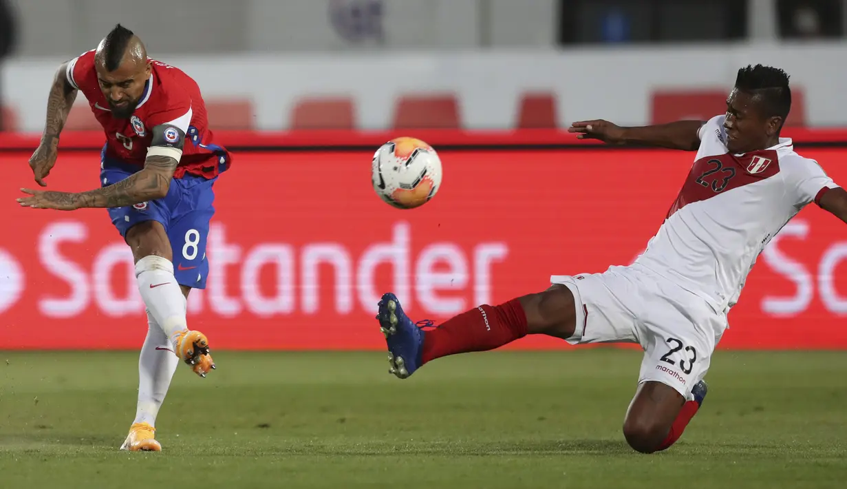 Gelandang Chile, Arturo Vidal menendang bola melewati pemain Peru, Pedro Aquino untuk mencetak gol dalam laga Kualifikasi Piala Dunia 2022 zona Conmebol di Estadio Nacional, Santiago, Jumat (13/11/2020). Chile mengalahkan Peru 2-0 berkat gol yang diborong Arturo Vidal. (IVAN ALVARADO/ POOL/ AFP)