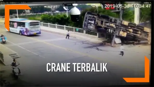 Dua orang pria lolos dari maut setelah kabur tepat waktu ketika sebuah crane mendadak terbalik saat memasang papan iklan pada sebuah jembatan di China.