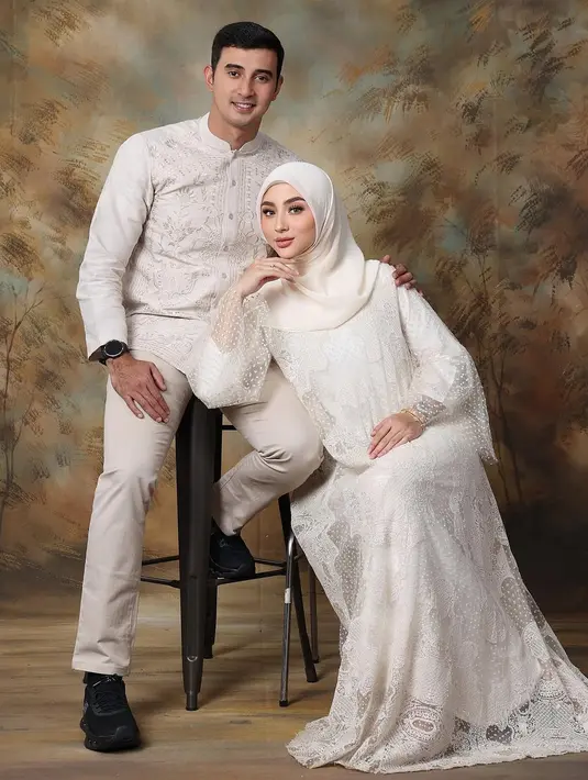 Margin Winaya tampil elegan kenakan dress lace putih dan hijab di foto keluarga. Ia terlihat serasi dengan suami yang kenakan baju koko bordir [@marginw]