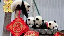 Anak-anak panda bermain di kandangnya dengan dekorasi Tahun Baru Imlek yang dikenal sebagai Tahun Babi, di provinsi Sichuan, China, 31 Januari 2019. Sebelas anak panda yang lahir pada tahun 2018 diperlihatkan kepada publik untuk menyambut Imlek. (STR/AFP)
