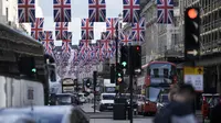 Lalu lintas bergerak melalui Regent Street yang dihiasi di pusat kota London Jumat, 5 Mei 2023. Penobatan Raja Charles III akan berlangsung di Westminster Abbey pada 6 Mei. (AP Photo/Markus Schreiber)