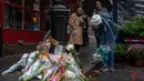 Para penggemar terlihat berkumpul di luar gedung, yang terletak di West Village, Manhattan, meninggalkan bunga-bunga di jalan dan mengambil foto-foto di tempat tersebut. (Adam GRAY / AFP)