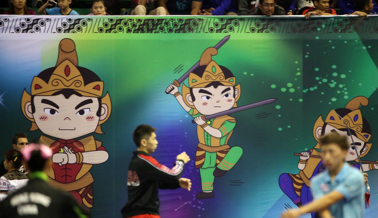 Para atlet Wushu, melakukan pemanasan dengan latar maskot Wushu 2015, sebelum bertanding pada Kejuaraan Dunia Wushu 2015 di Istora Senayan, Jakarta, Sabtu (14/11/20150). (Bola.com/Nicklas Hanoatubun)