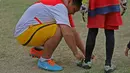 Membantu mengikat tali sepatu kiper saat berlatih di Stadion Tanah Lapang Ombilin, Sawahlunto, (8/11/2016). (Bola.com/Nicklas Hanoatubun)