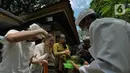 Umat Hindu diberikan air suci selama Upacara Tawur Agung Kesanga di Pura Aditya Jaya, Pulo Gadung, Jakarta Timur, Rabu (1/3/2022). Upacara ini bermakna sebagai wujud keselarasan antara umat manusia dengan alam.  (Liputan6.com/Herman Zakharia)