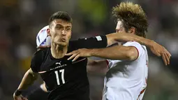 Gelandang Austria, Dejan Ljubicic berebut bola dengan pemain Denmark, Joachim Andersen pada pertandingan UEFA Nations League di Stadion Ernst Happel di Wina, Austria, Selasa (7/6/2022). Denmark menang tipis atas Austria 2-1. (AP Photo/Andreas Schaad)