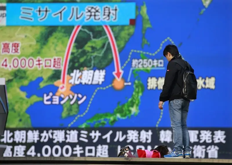 Tayangan berita di Tokyo yang menampilkan visualisasi rudal Korea Utara yang meluncur pada 29 November 2017. Rudal itu jatuh di Laut Jepang, atau 1.000 km dari titik peluncuran awal, setelah terbang ke angkasa setinggi 4.500 km (AP/Shizuo Kombayashi)