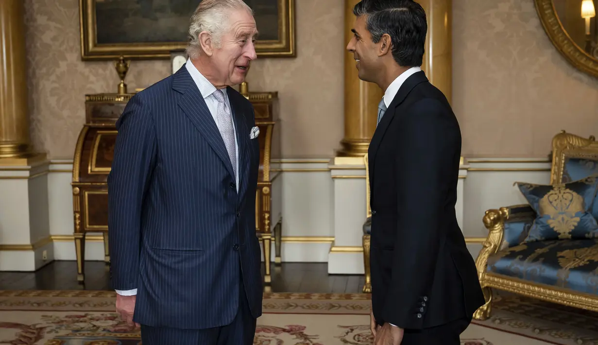 Raja Charles III menyambut Rishi Sunak selama audiensi di Istana Buckingham, London, di mana ia mengundang pemimpin Partai Konservatif yang baru terpilih untuk menjadi Perdana Menteri dan membentuk pemerintahan baru, Selasa, 25 Oktober 2022. (Aaron Chown/Pool photo via AP)