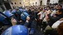 Polisi anti huru-hara (kiri) menggunakan tongkat untuk melawan pengunjuk rasa saat bentrokan dalam aksi protes oleh pemilik restoran dan aktivitas bisnis lainnya di luar parlemen di Piazza Montecitorio di Roma, Selasa (6/4/202). Mereka menuntut untuk membuka kembali bisnis. (Filippo MONTEFORTE/AFP)