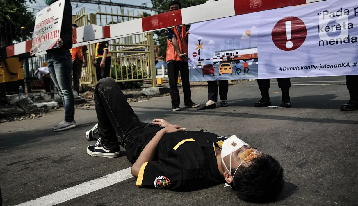 Aksi teatrikal sosialisasi keselamatan di perlintasan kereta api sebidang, Kemayoran, Jakarta, Rabu (14/10/2020). PT KAI Daop 1 menggelar sosialisasi dan aksi teatrikal dalam rangka menekan angka kecelakaan yang kerap terjadi di perlintasan sebidang. (merdeka.com/Iqbal Nugroho)