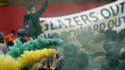 Para pendukung Manchester United melakukan demonstrasi menentang Keluarga Glazer, pemilik sebagian besar saham Manchester United di luar Stadion Old Trafford sebelum laga lanjutan Liga Inggris 2020/2021 pekan ke-35 melawan Liverpool, Kamis (13/5/2021). (AP/Jon Super/Pool)