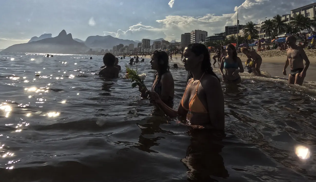 Pemuja dewi laut Yemanja menempatkan persembahan bunga  di perairan pantai Arpoador selama perayaan tahunan di Rio de Janeiro, Brasil, Kamis, 2 Februari 2023. Dalam kepercayaan Afro-Brasil, Yemanja diyakini sebagai representasi dewi laut yang cantik jelita. (AP Photo/Bruna Prado)