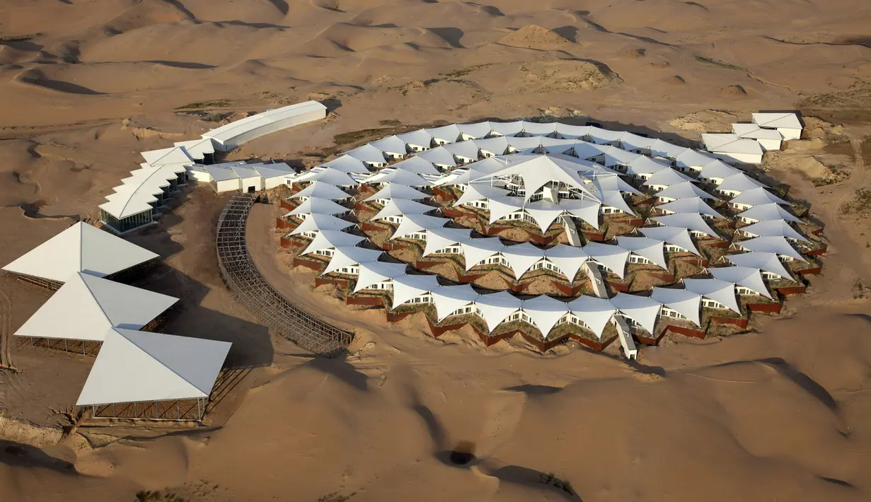 Desert Lotus Hotel dibangun di tengah gurun padang pasir Xiangshawan, Mongolia. Hotel ini didesain seperti tenda-tenda yang bila dilihat dari atas akan terlihat seperti lingkaran dalam gurun tandus Xiangshawan. (chictraveler.com)