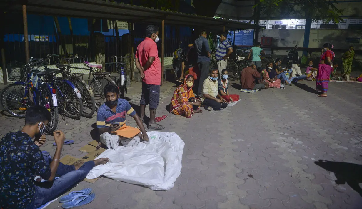 Orang-orang berkemah semalam untuk mendapatkan vaksin Covid-19 pada hari berikutnya di rumah sakit distrik yang dikelola pemerintah di Siliguri, negara bagian Bengal Barat, India, Senin (20/9/2021). Hingga 19 September 2021, sebanyak 202 juta orang India telah divaksin dua dosis (Diptendu DUTTA/AFP)