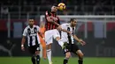 Penyerang muda AC Milan, Cutrone saat melakukan duel udara dengan Chiellini pada lanjutan laga serie a yang berlangsung di stadion San Siro, Milan (12/11). AC Milan kalah 0-2. (AFP/Marco Bertorello)