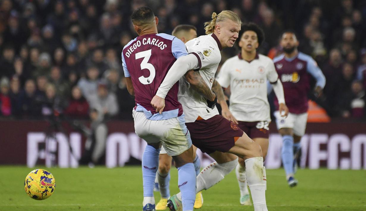 Pemain Manchester City, Erling Haaland, berusaha melewati pemain Aston Villa, Diego Carlos, pada laga lanjutan pekan ke-15 Premier League di Stadion Villa Park, Kamis (07/12/2023). Man City di luar dugaan takluk saat bertandang ke markas The Villans. (AP Photo/Rui Vieira)