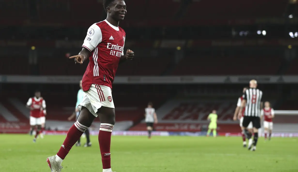 Gelandang Arsenal, Bukayo Saka berselebrasi usai mencetak gol ke gawang Newcastle United pada pertandingan Liga Inggris di Stadion Emirates di London, Selasa (19/1/2021). (Catherine Ivill/Pool via AP)