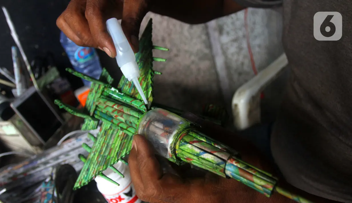 Perajin menyelesaikan miniatur pesawat di bengkel Workshop kawasan Kemandoran 8 Jakarta Selatan, Senin (10/2/2020). Berbagai kerajinan tangan berbahan dasar koran bekas dijual dengan harga Rp. 50.000 ribu hingga Rp. 150 ribu tergantung tingkat kesulitan dalam pengerjaan. (merdeka.com/Arie Basuki)