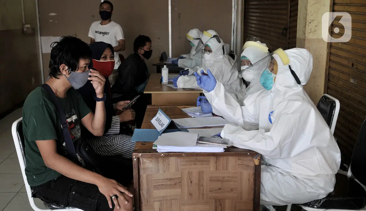 Pedagang menjalani rangkaian pemeriksaan sebelum mengikuti Tes Swab Covid-19 di Pasar Kramat Jati, Jakarta, Rabu (17/6/2020). Ratusan pedagang Pasar Kramat Jati menjalani tes swab secara bertahap sebagai upaya pemerintah memutus rantai penyebaran virus Covid-19. (merdeka.com/Iqbal S. Nugroho)