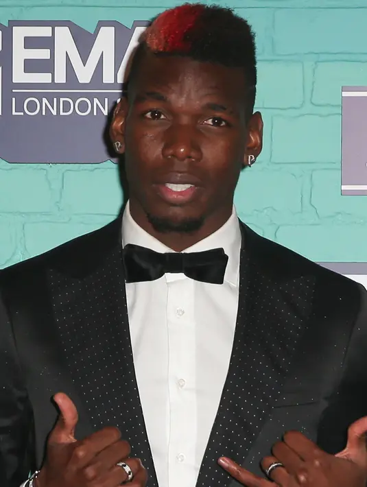 Gelandang MU, Paul Pogba berpose di atas karpet merah saat menghadiri MTV Europe Music Awards (EMA) 2017 di Wembley Arena di London, Inggris (12/11). Paul Pogba tampil keren dengan jas dan rambut di cat merah. (AFP Photo/Daniel Leal-Olivas)