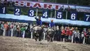 Joki berusaha mengendalikan kerbaunya dalam perlombaan balap kerbau tahunan di Provinsi Chonburi, selatan Bangkok, Thailand, Sabtu (12/10/2019). Para petani merayakan dimulainya musim tanam dengan mengadakan adu balap kerbau, hewan yang biasanya membajak lahan. (Lillian SUWANRUMPHA/AFP)