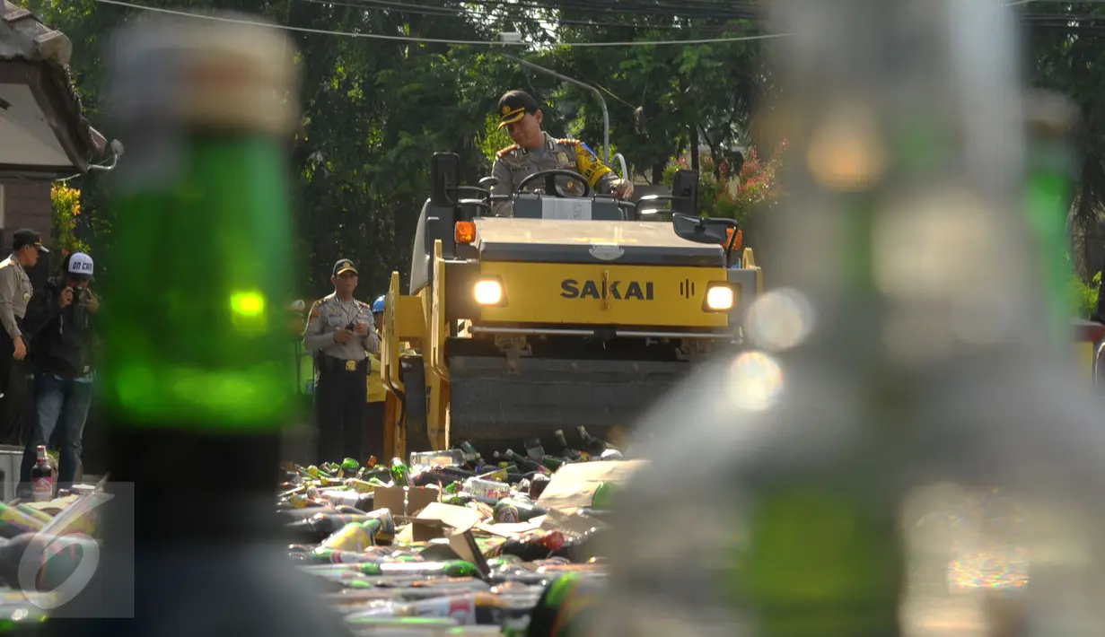 Polisi menggunakan alat berat saat memusnahkan ribuan botor miras di Polres Kota Tangerang Banten, Rabu, (23/12). Kapolres Kota Tangerang Turun tangan langsung atas tindakan pemusnahan. (Liputan6.com/Faisal R Syam)