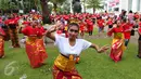 Seorang wanita melakukan pemanasan sebelum mengikuti flash mob tari pendet asal Bali di Museum Nasional Indonesia Jakarta, Sabtu (23/4). Kegiatan ini menyambut peringatan ulang tahun Museum Nasional Indonesia pada 24 April 2016 (Liputan6.com/Angga Yuniar)