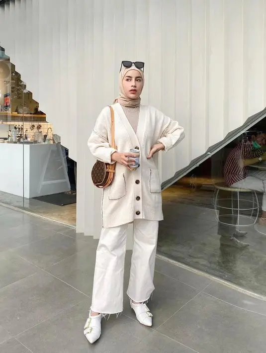 Cocok untuk musim dingin, padukan knit cardigan dengan kulot putih dan hijab warna nude. Tambahkan pula aksesori berupa kacamata  untuk look yang chic. (Instagram/emyaghnia).