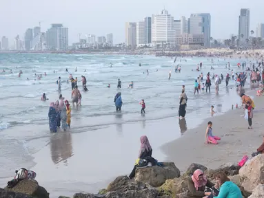 Muslim Palestina bermain dan berenang saat menghabiskan hari libur Lebaran di pantai Tel Aviv, Israel, 6 Juni 2019. Selama Idul Fitri, warga Palestina mengunjungi pantai di kawasan Tel Aviv untuk menandai berakhirnya ibadah puasa Ramadan. (AP Photo/Oded B