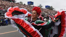 Penari asal Meksiko saat tampil pada parade mawar ke 128 di Pasadena, California, AS (2/1). Parade ini menghadirkan kendaraan berhias bunga, marching band, serta unit pasukan berkuda yang diikuti para atlet football. (AP Photo/Michael Owen Baker)