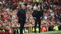 Aksi pelatih Manchester United, Jose Mourinho (kiri) dan pelatih  Manchester City, Pep Guardiola (R) saat menyaksikan anak asuhnya berlaga pada laga Premier League di Old Trafford, Manchester,  (10/9/2016). (AFP/Oli Scarff)