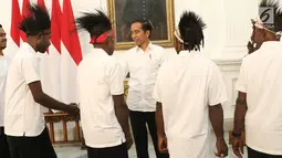 Presiden Joko Widodo (Jokowi) menyambut kedatangan pemenang lomba festival Gapura Cinta Negeri di Istana Merdeka, Jakarta, Selasa (3/9/2019). Jokowi mengundang pemenang lomba festival Gapura Cinta Negeri yang merupakan warga Kabupaten Yapen dan Kabupaten Nduga, Papua. (Liputan6.com/Angga Yuniar)