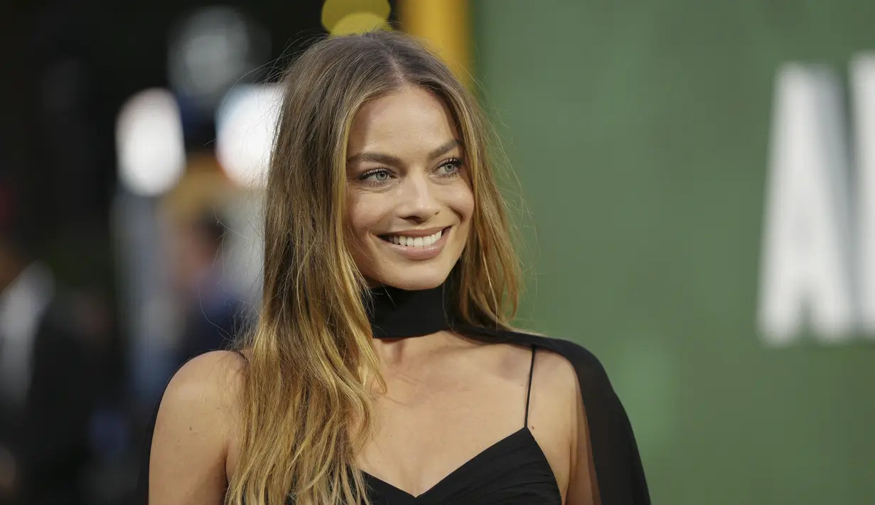 Margot Robbie tersenyum setibanya di pemutaran perdana film 'Amsterdam' di London, Rabu, 21 September 2022. Gaun di sekitar dadanya ada potongan sementara pinggangnya menampilkan potongan yang menganga. (Photo by Vianney Le Caer/Invision/AP)