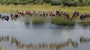 Sejumlah orang bergelantungan dengan tali usai melompat dari jembatan berketinggian 30 meter di Hortolandia, Brasil, Minggu (10/4). Sebanyak 149 orang mencoba membuat rekor dunia dengan melompat bersama dari atas jembatan. (REUTERS/Paulo Whitaker)