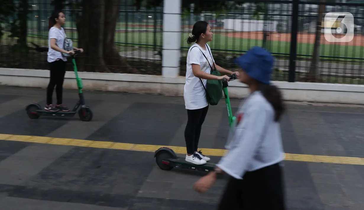 Pengguna otoped listrik Grabwheels melintas di trotoar Jalan Jenderal Sudirman, Jakarta, Kamis (14/11/2019). Pemprov DKI Jakarta melarang penggunaan otoped listrik di trotoar, Jembatan Penyeberangan Orang (JPO) serta pada pelaksanaan Hari Bebas Kendaraan. (Liputan6.com/Helmi Fithriansyah)