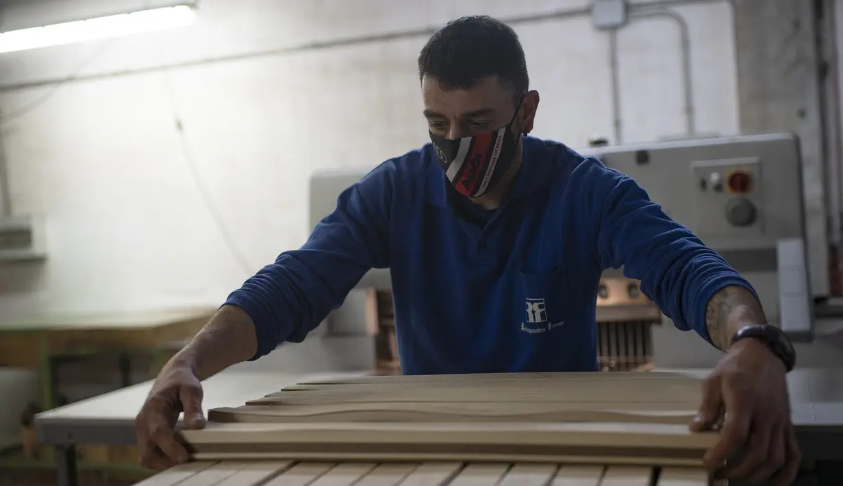 Karyawan Rechapados Ferrer membuat papan catur di La Garriga dekat Barcelona (5/3/2021). Penjualan pembuat papan catur Spanyol itu melonjak sejak ditampilkan di serial Netflix terkenal "The Queen's Gambit". (AFP Photo/Josep Lago)