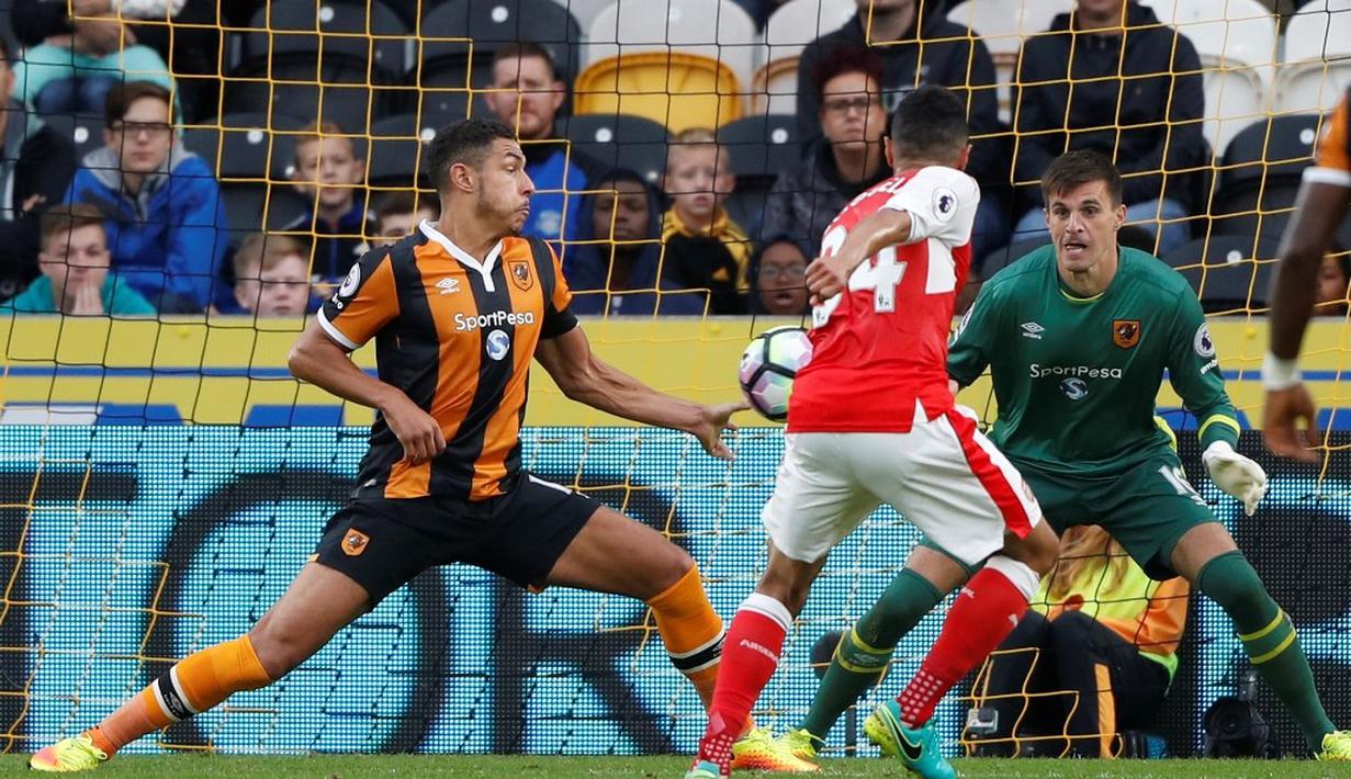 Pemain Hull City, Jake Livermore (kiri), menyentuh bola tendangan pemain Arsenal, Laurent Koscielny, pada laga lanjutan Premier League, di KCOM Stadium, Sabtu (17/9/20106). (Reuters/Russell Cheyne)