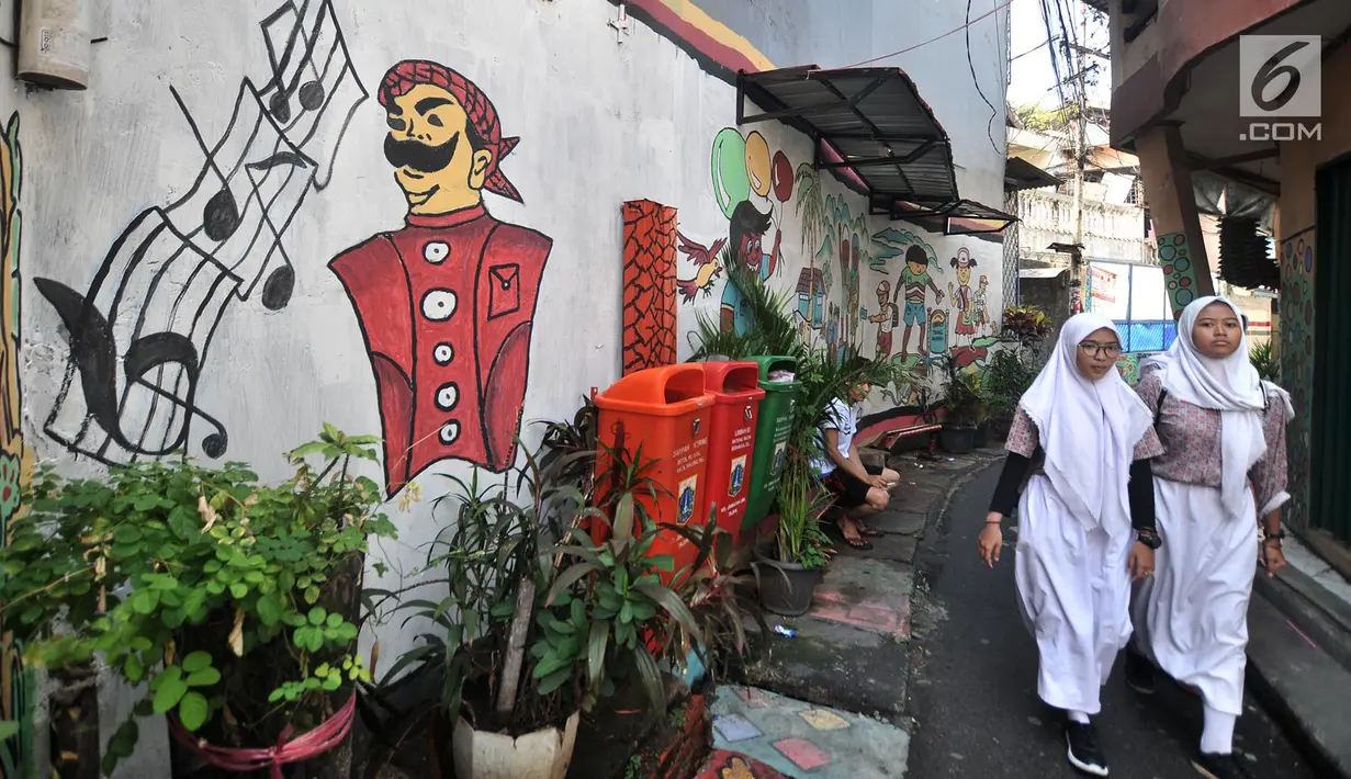 Anak sekolah melintas di depan lukisan tembok atau mural yang menghiasi gang di RT 13 RW 06, Jembatan Lima, Jakarta, Kamis (10/1). Warna-warni mural di pemukiman padat penduduk itu merupakan ide Aryanto selaku Ketua RT 13. (Merdeka.com/Iqbal Nugroho)
