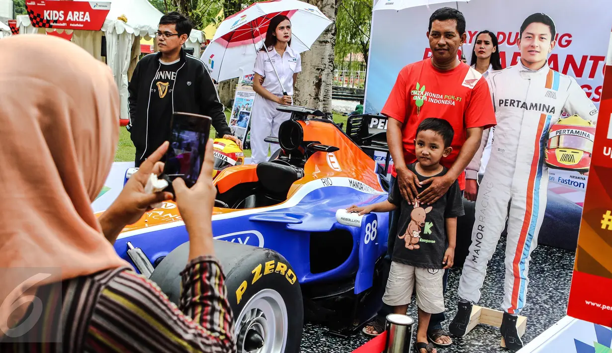 Pengunjung berfoto bersama di replika mobil Formula 1 yang ditunggangi pembalap Indonesia, Rio Haryanto pada acara Nonton Bareng F1 GP Australia 2016 Pertamina di Mall Bintaro Xchange, Tangerang Selatan, Minggu (20/3). (Liputan6.com/Fery Pradolo)