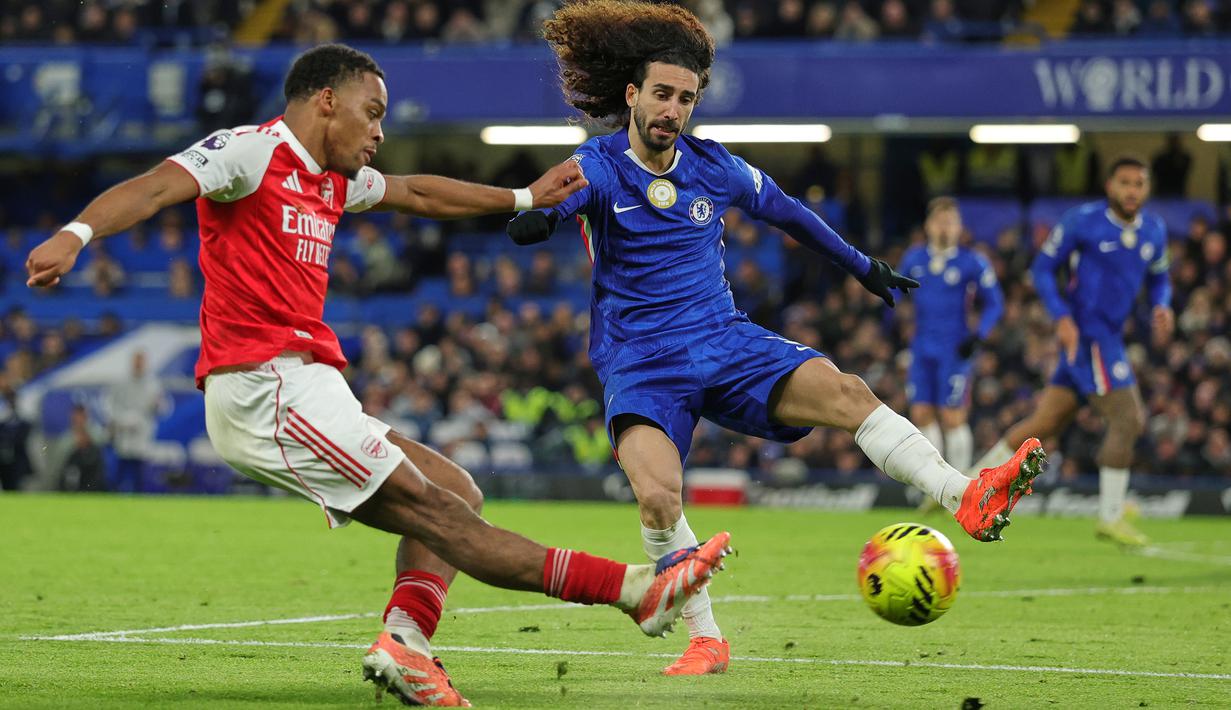 Pemain Arsenal, Jurrien Timber (kiri) berusaha melepaskan tembakan dibayangi pemain Chelsea, Marc Cucurella dalam laga lanjutan Liga Inggris 2025/2026 di Stamford Bridge, London, Minggu (30/11/2025). (AP Photo/Ian Walton)
